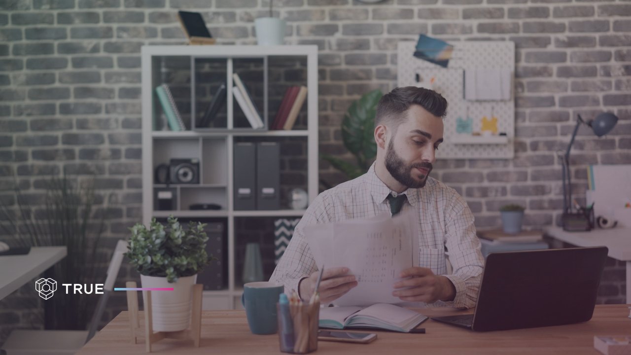 an administrator compares paper records with his laptop, the manual checking that a certificate verification system takes over for a company, a school or a public authority